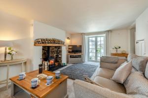 ein Wohnzimmer mit Couch und Kamin in der Unterkunft Annies Cottage - Appledore in Appledore