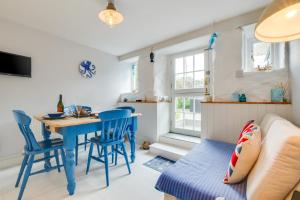 a living room with a blue table and chairs and a couch at Seahorse Cottage in Mousehole