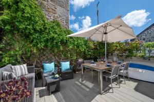 a patio with a table and chairs and an umbrella at Seahorse Cottage in Mousehole