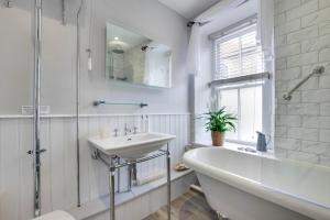 a bathroom with a bath tub and a sink and a bath tub at Seahorse Cottage in Mousehole +26 photos