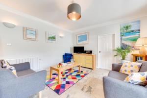 a living room with two chairs and a table at Pebbles Marazion in Marazion