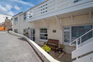 a building with a bench in front of it at Pebbles Marazion in Marazion