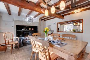 a kitchen and dining room with a wooden table and chairs at Rooks Cottage in Askrigg