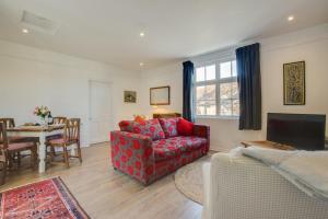 a living room with a red couch and a table at Old Mill Cottage in Gweek