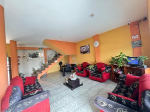 a living room with red couches and a staircase at La Casa de Jeimy in Puerto Baquerizo Moreno