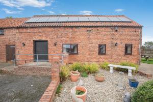 Lark Rise Cottage - 3 White Hoe Farm في Kirton in Lindsey: منزل من الطوب وألواح شمسية على السطح