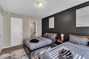 ダーラムにあるCharming King 2BR Suite in Research Triangle Parkのベッドが2つあり、壁が黒い寝室