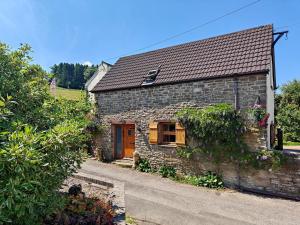 a small stone house with a wooden door and aphalt at Annes Cottage in Lydbrook