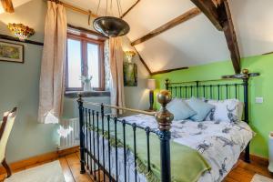 a bedroom with green walls and a bed at Annes Cottage in Lydbrook