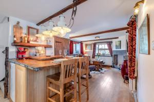 a kitchen with a bar with wooden counter tops at Annes Cottage in Lydbrook +22 photos