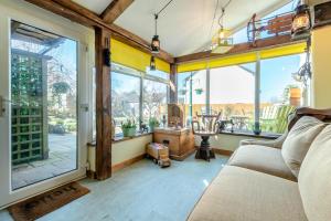 a living room with a couch and large windows at Annes Cottage in Lydbrook