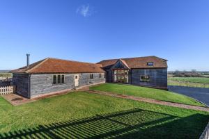 a house on a grassy hill with a large yard at The Old Cowshed in Stone