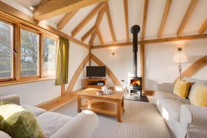 a living room with a couch and a table at The Old Cowshed in Stone
