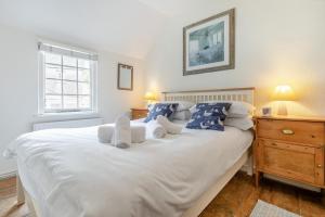 a bedroom with a large white bed with blue pillows at Shell Cottage 10 St Peters Street in St Ives