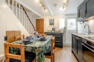 a kitchen with a table with chairs and a sink at Shell Cottage 10 St Peters Street in St Ives