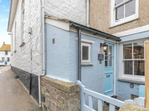 a blue building with a blue door on a street at Shell Cottage 10 St Peters Street in St Ives