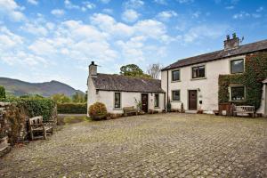 a large white house with a stone driveway at Rosie Cottage in Bassenthwaite