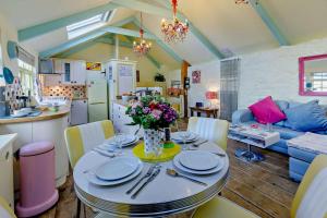 a kitchen and living room with a table with flowers on it at Eias Loft - St Ives in St Ives