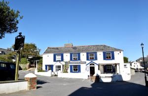 a white building with blue trim on a street at Rolling Hills in Woolacombe