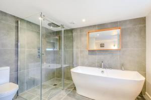 a bathroom with a tub and a shower and a toilet at Rolling Hills in Woolacombe