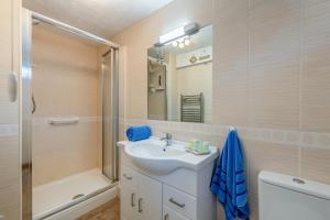 Un baño con lavabo, ducha y espejo. en Saltwhistle Beach, en Teignmouth 24 fotos más