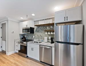 a kitchen with white cabinets and a stainless steel refrigerator at Carters Court Cozy Hideaway in Franklin +13 photos