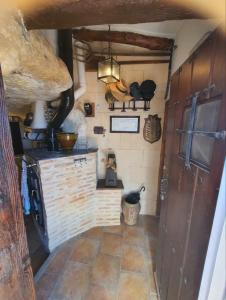 a kitchen with a stove and a wall with artifacts at Cueva a 10 min de Albacete in Chinchilla de Monte Aragón +2 photos