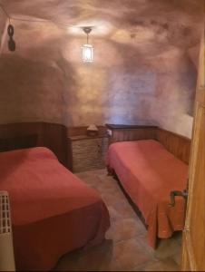 a bedroom with two beds in a room with a ceiling at Cueva a 10 min de Albacete in Chinchilla de Monte Aragón
