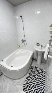 een witte badkamer met een bad en een wastafel bij Al-Sabur in Samarkand +12 foto's