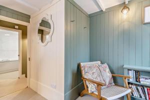 a room with a chair and a book shelf at Trehawn Cottage in Saint Columb Major +18 photos