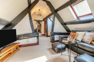 a living room with a couch and a tv at Riverside Barn - LLangorse in Llangorse