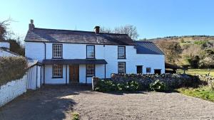 a white house with a fence in front of it at Lower Lock Cottage in Llangynidr