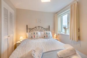a bedroom with a bed with pillows and a window at Iona Cottage - Allonby in Allonby