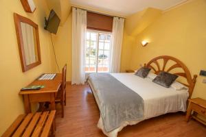a bedroom with a bed and a table and a window at Hotel Restaurante Isape GBC in Arcade +167 photos