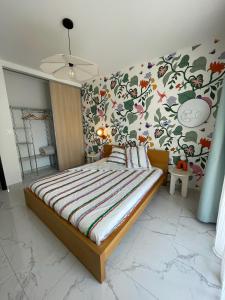 a bedroom with a large bed with a floral wallpaper at Héliotrope - 3 chambres in Propriano