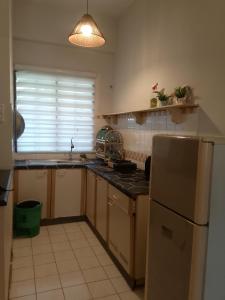 a kitchen with a sink and a refrigerator at mySeahome Corus Paradise in Port Dickson