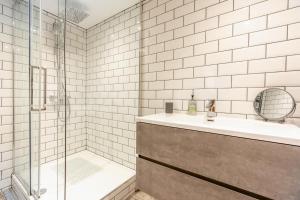 ウィットビーにあるThe Admirals Room - Whitbyの白いタイル張りのバスルーム(シンク、シャワー付) +16枚の写真