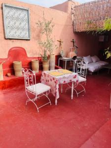 Zimmer mit einem Tisch und Stühlen auf einer roten Etage in der Unterkunft Hannah House Marrakech in Marrakesch