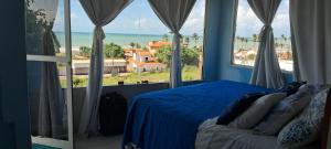 a bedroom with a bed with a view of the ocean at Vistamar Arco das Flores in Taíba +9 photos