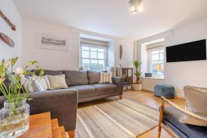 a living room with a couch and a tv at River Watch - Fowey in Fowey