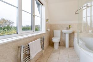 un bagno con un water, un lavandino e una finestra di Orchard Cottage a Preesgreen Altre 17 foto