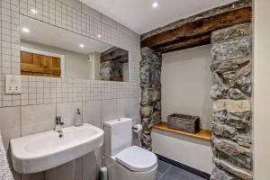 a bathroom with a white toilet and a sink at Parlwr Mawr in Dyffryn +23 photos