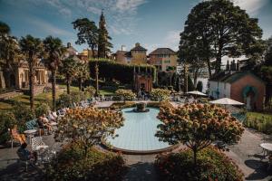a courtyard with a fountain and trees and buildings at Parlwr Mawr in Dyffryn