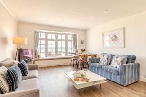 a living room with two couches and a table at Harbour Sands - St Ives in St Ives