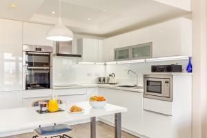 a white kitchen with a table with a bowl of food on it at Harbour Sands - St Ives in St Ives