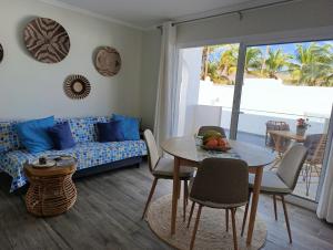 a living room with a table and a couch at Casa Esterlita in Tarajalejo