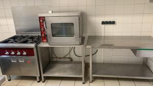 a kitchen with a stove and a microwave at A la queue du Milan - Gîte in Pionsat