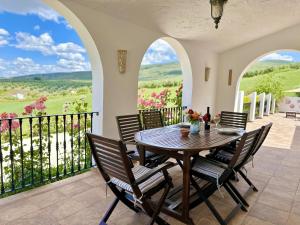 a dining room with a table and chairs on a balcony at Casa Moya in Alcalá la Real