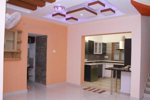 a kitchen with orange walls and a table in it at Harsharav in Palakkad +11 photos