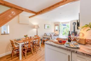 eine Küche und ein Wohnzimmer mit Tisch und Stühlen in der Unterkunft Archway Cottage - Caldbeck in Caldbeck